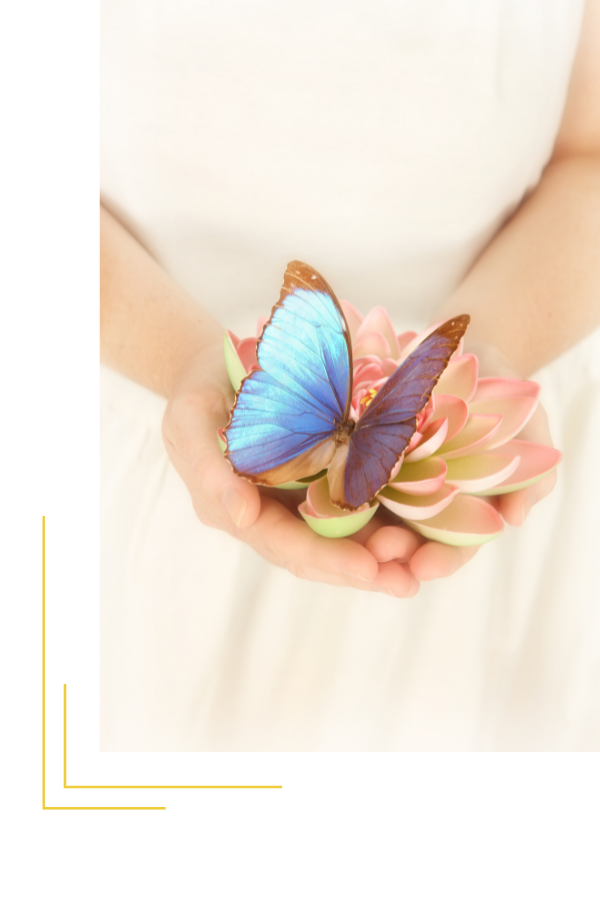 Eine Frau hält eine Lotusblüte in der Hand mit einem blauen Schmetterling darauf